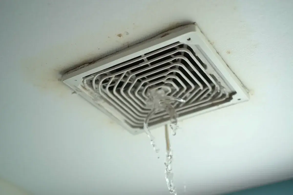 Condensation droplets forming on a ceiling supply vent in a humid Valley home